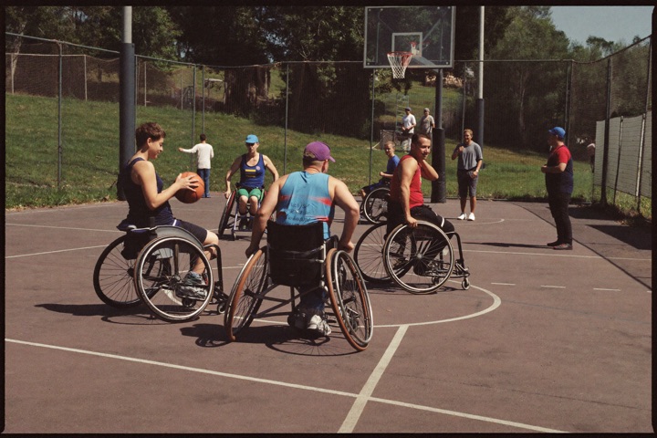 Sporters spelen rolstoelbasketbal tijdens een sportdag in de buitenlucht