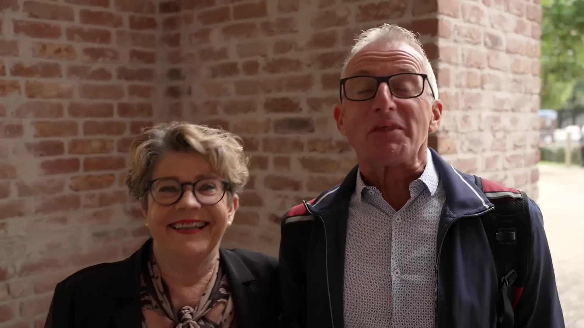 Twee ervaringsdeskundigen lachen voor een bakstenen muur in de film Zo makkelijk is het!