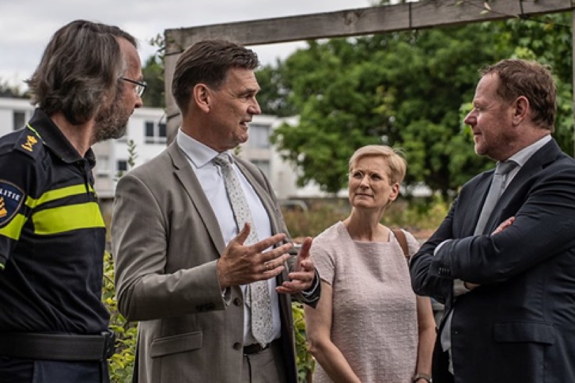 Wijkagent en medewerkers van de gemeente in gesprek tijdens een werkbezoek in de wijk