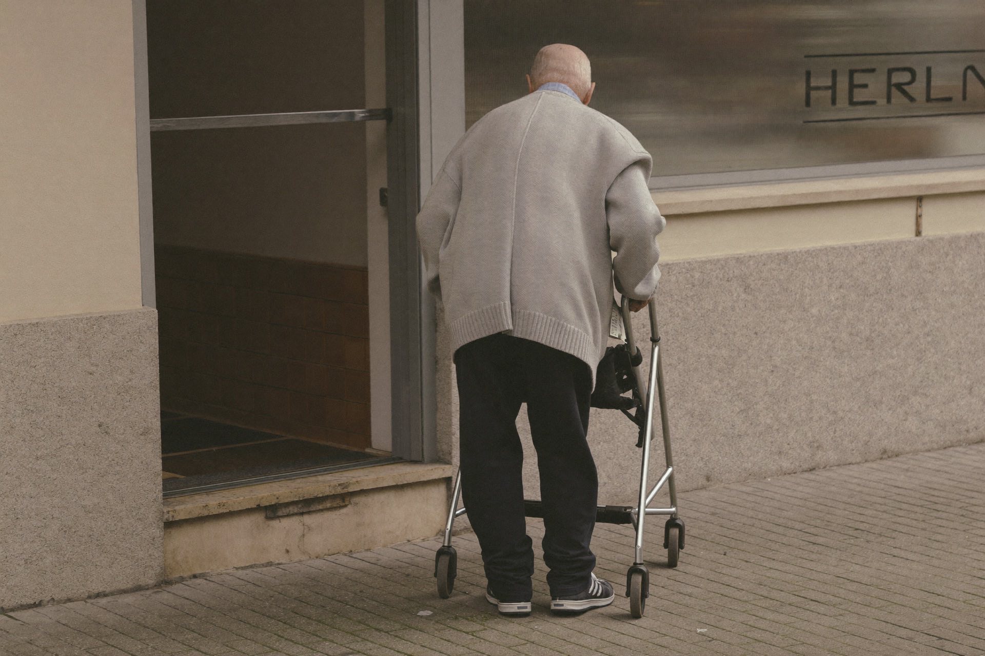 Winkelingang met hoge drempel waar iemand met een rollator niet naar binnen kan